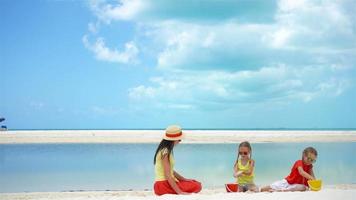 Adorable little girls and young mother on white beach video