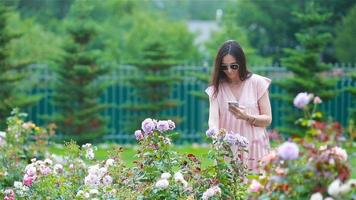 Young girl in a flower garden among beautiful roses. Smell of roses video
