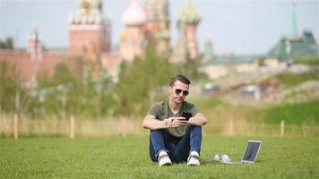 Man is working by laptop while relaxing in the park video