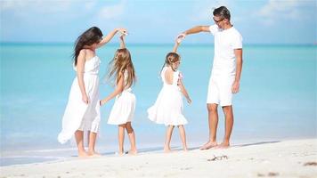 familia joven divirtiéndose en la playa caribeña tropical blanca video