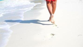 vrouw poten rennen langs de wit strand in Ondiep water. concept van strand vakantie en blootsvoets. langzaam beweging. video