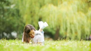 linda mulher está lendo mensagem de texto no celular enquanto está sentado no parque. video