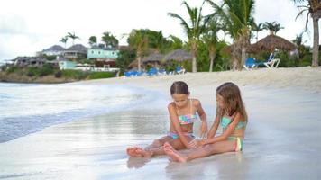 Entzückende kleine Mädchen, die mit Sand am Strand spielen. video