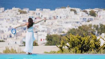 belle jeune femme se relaxant près de la piscine avec une vue imprenable sur mykonos, grèce video