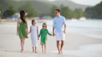 familie van vier die op wit strand lopen video