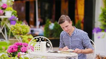 Caucasian young european man in outdoors cafe. Portrait of attractive young tourist have dinner. video