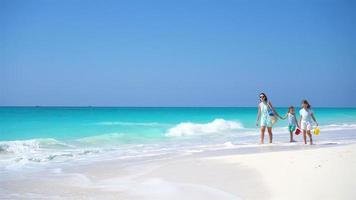 Family of mother and kids walking on white beach video