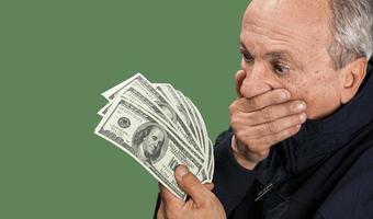 Senior gentleman holding a stack of money photo