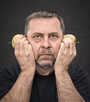 hombre de mediana edad con manzanas verdes foto