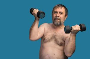 elderly fat man exercising with dumbbells photo