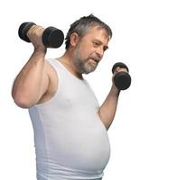 Fat middle-aged man exercising with dumbbells photo