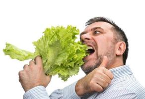 un hombre con un manojo de lechuga para una alimentación saludable foto