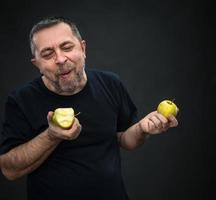 hombre de mediana edad con manzanas verdes foto