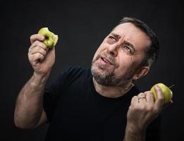 hombre de mediana edad con manzanas verdes foto