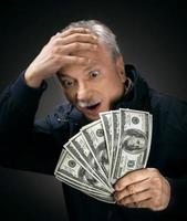 Senior gentleman holding a stack of money photo