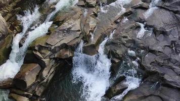 Waterfall top down view. Top view of the stream, water flows over the stones. rocky mountain waterfall. aerial landscape mountain rocky cascade river stream natural scenic background picture. video