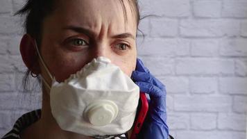 jong vrouw pratend Aan de telefoon met emoties van ongerustheid en Gevaar in een wit medisch beschermend masker. beschermen anderen van bacterie en coronavirussen. de Rechtsaf voorzorgsmaatregelen voor epidemieën. video