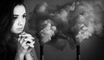 praying woman against of pipes polluting an atmosphere photo