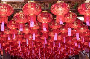 linterna china asiática con tarjeta de felicitación colgada en el templo del techo en la celebración del año nuevo foto