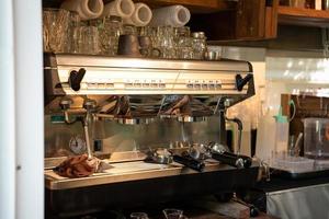 Automatic coffee machine with bottomless portafilter and glass in coffee shop photo