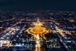 Majestic golden pagoda of Phra Pathom Chedi glowing among the festival lights around the roundabout road in downtown at Nakhon Pathom photo