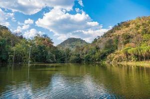 paisaje de montaña con estanque natural y cielo azul en la selva tropical foto