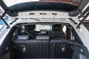 Rear of an SUV car with unpack parts and camera equipment installed in workshop photo