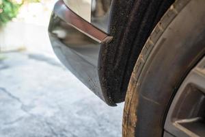 Tarmac and mud stains on rear of black plastic bumper car photo