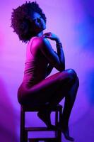 mujer negra sensual bajo luz de neón foto