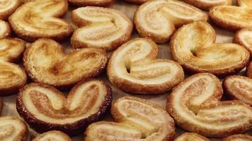 Rotating close up of fresh palm puff pastry in the shape of a heart. French biscuits with elephant ears. Close-up. video