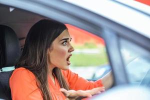 mujer conductora estresada sentada dentro de su auto. conductora enojada conduciendo un auto. mujer joven enojada atrapada en un atasco de tráfico. mujer molesta en coche. chica atrapada en el tráfico. foto