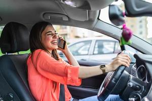 mujer de negocios conduciendo un coche y hablando por teléfono celular concentrándose en la carretera. conducir mientras se sostiene un teléfono móvil uso del teléfono celular mientras se conduce. mujer en coche hablando por teléfono móvil mientras conduce foto