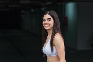 hermosa chica fitness caminando en el gimnasio, joven mujer bonita en retrato de ropa deportiva foto