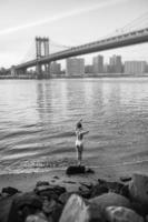 mujer joven de pie en la orilla del río este foto