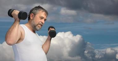 hombre gordo de mediana edad haciendo ejercicio con pesas foto