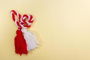 a martisor isolated on light yellow background photo