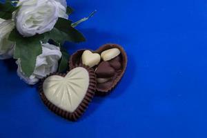 bombones de chocolate con forma de corazón y rosas blancas foto