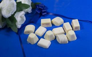variety of sweet chocolate bonbons and white roses photo