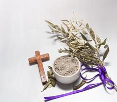 bowl with ashes and olive branch. ash wednesday concept photo