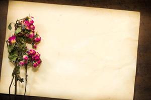 concepto de pasar el tiempo con flores marchitas en papeles viejos foto