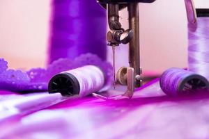 máquina de coser antigua y elementos de costura en tonos violetas foto
