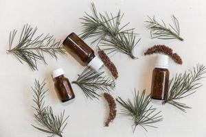 Top view bottles with cedar oil. Aromatherapy and natural cosmetics concept background photo