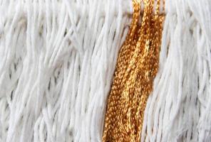 texture of wool fringe and white and gold threads photo