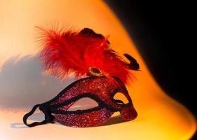 máscara de símbolo de carnaval en color rojo dorado con plumas foto