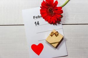 caja dorada con anillos de flores y nota para el día de san valentín foto