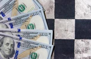 finance concept with dollar bills on chessboard photo