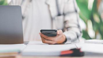 documentos contables comerciales, auditor, gestión y auditoría de documentos de oficina, informes para análisis de tiempo de impuestos, trabajador de oficina con teléfono inteligente trabajando con documentos en el escritorio foto