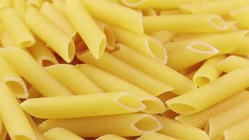 langzaam spinnen rauw penne rigeren is een kort pasta met schuin bezuinigingen en een geribbeld oppervlak. traditioneel Italiaans pasta. niet krijgen zit vast. visie van bovenstaande. video