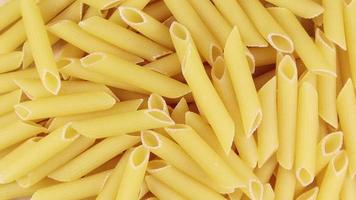 langzaam spinnen rauw penne rigeren is een kort pasta met schuin bezuinigingen en een geribbeld oppervlak. traditioneel Italiaans pasta. niet krijgen zit vast. visie van bovenstaande. video