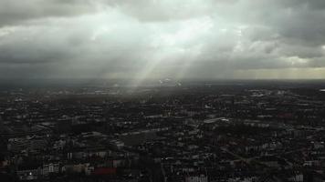 view from a high tower on a cityscape. Houses and architecture with roads and cars, people. Sun rays shining through the clouds on the morning city. video